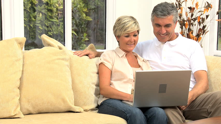Middle Aged Couple Using Laptop At Home Stock Footage