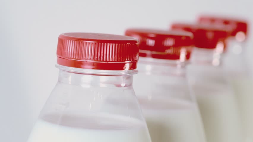 part-of-four-bottles-of-milk-with-red-cap-isolated-on-white-stock