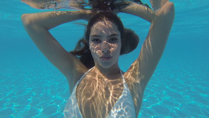 Beautiful Girl In A White Bikini Swimming In The Pool